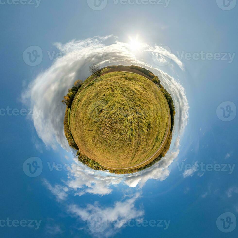 simple tiny planet without buildings in blue sky with beautiful clouds. Transformation of spherical panorama 360 degrees. Spherical abstract aerial view. Curvature of space. photo