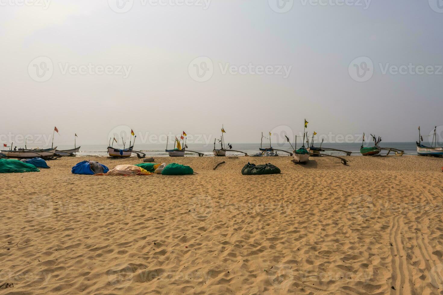 old fishing boats in sand on ocean in India on blue sky background photo