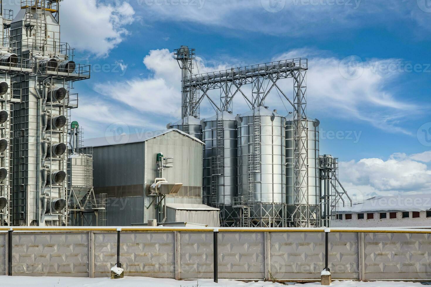 modern agro-processing plant for processing and silos for drying cleaning and storage of agricultural products, flour, cereals and grain in snow of winter field photo