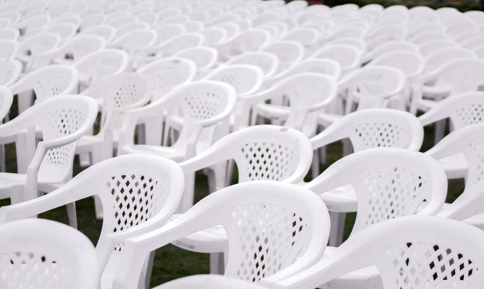 de cerca y cosecha blanco el plastico sillas poner en forrado en filas para estudiantes en el graduación ceremonia. foto