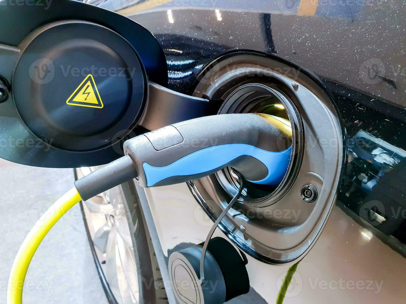 Closeup electronic dispenser refueling to Electric car at electric station. Electric cars began to gain popularity because is a safe choice energy, more environmentally friendly than use gasoline. photo