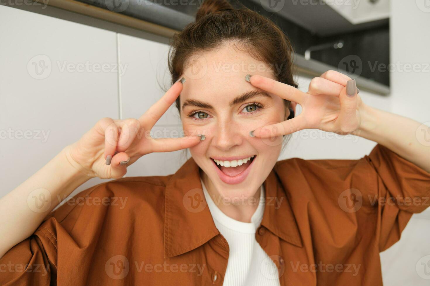 Close up portrait, face of happy woman, enjoying listening to music, wearing wireless headphones, laughing and smiling photo