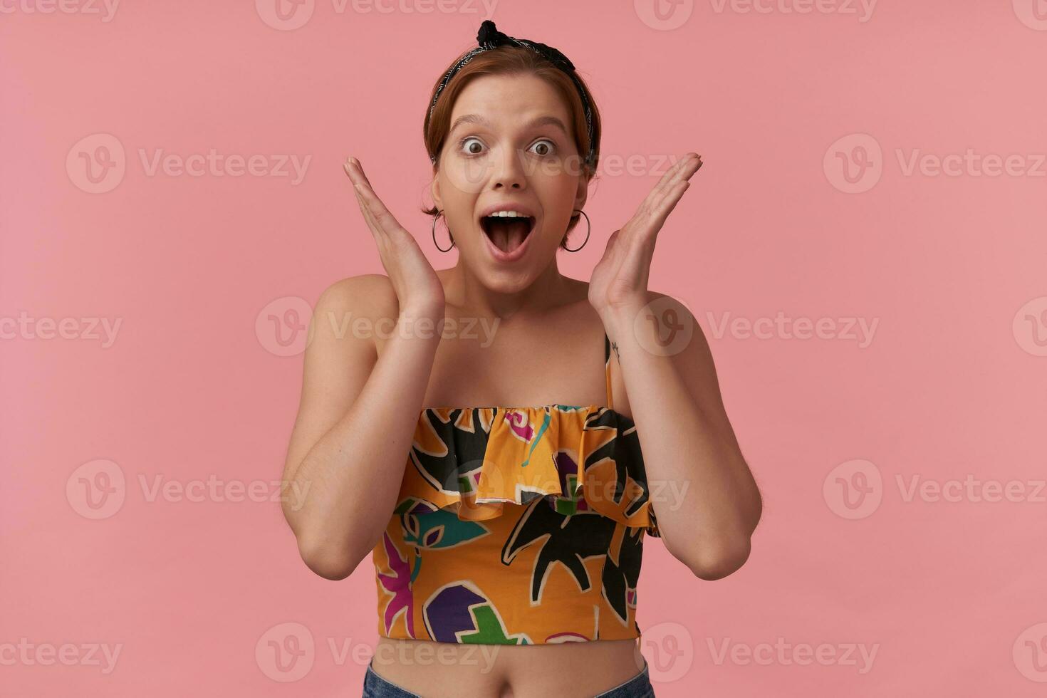 Image of lovely european young woman with natural makeup wearing stylish summer crop and bandana surprised exciting emotion with arms around face isolated posing against pink background photo