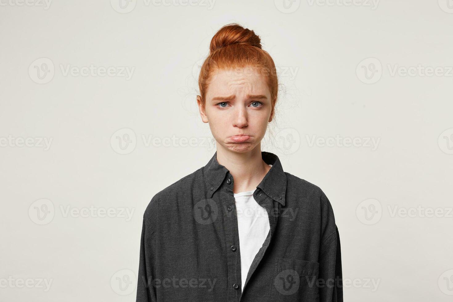 Offended upset sad young girl dressed in casual black shirt, on her face expression of insult sadness, lower lip pout, depicts a grudge, isolated on white background photo