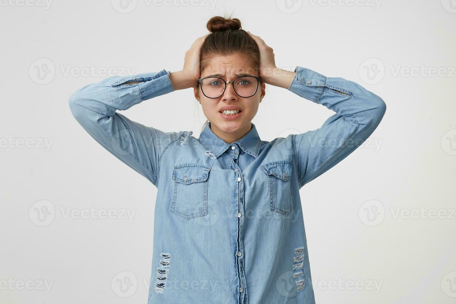 The girl clutched at her head in a panic in despair, doesnot know where to run or what to do. Oh my God, disaster, gritted her teeth isolated on a white background. photo