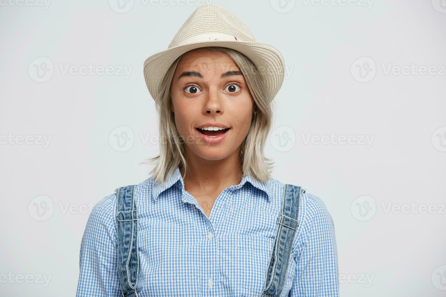 Astonished delighted, recognized something unusual, new, young girl in a hat,dressed in casual clothes, on her face an expression of amazement. photo