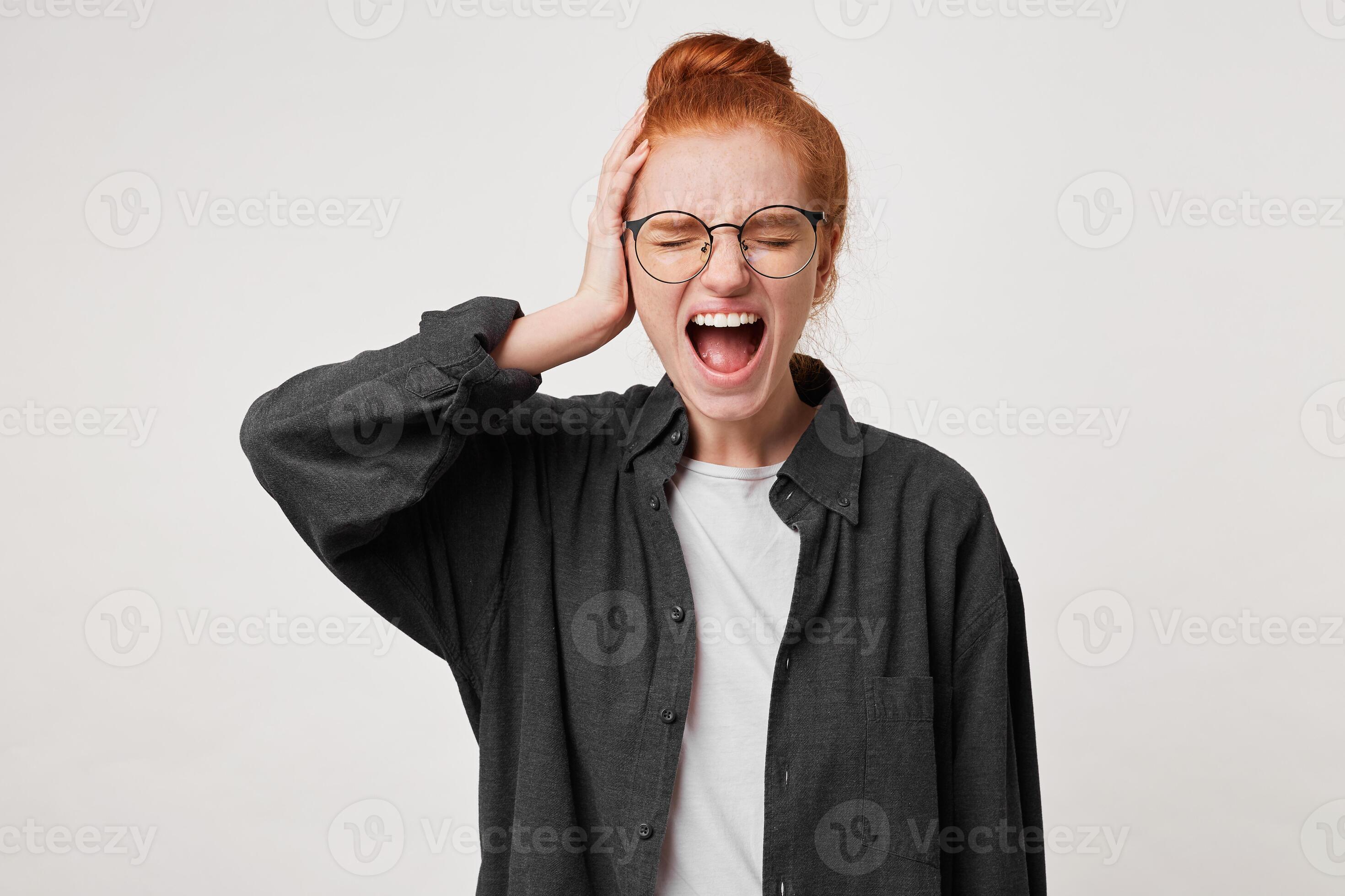 A redhaired young girl with glasses dressed in a black man's shirt