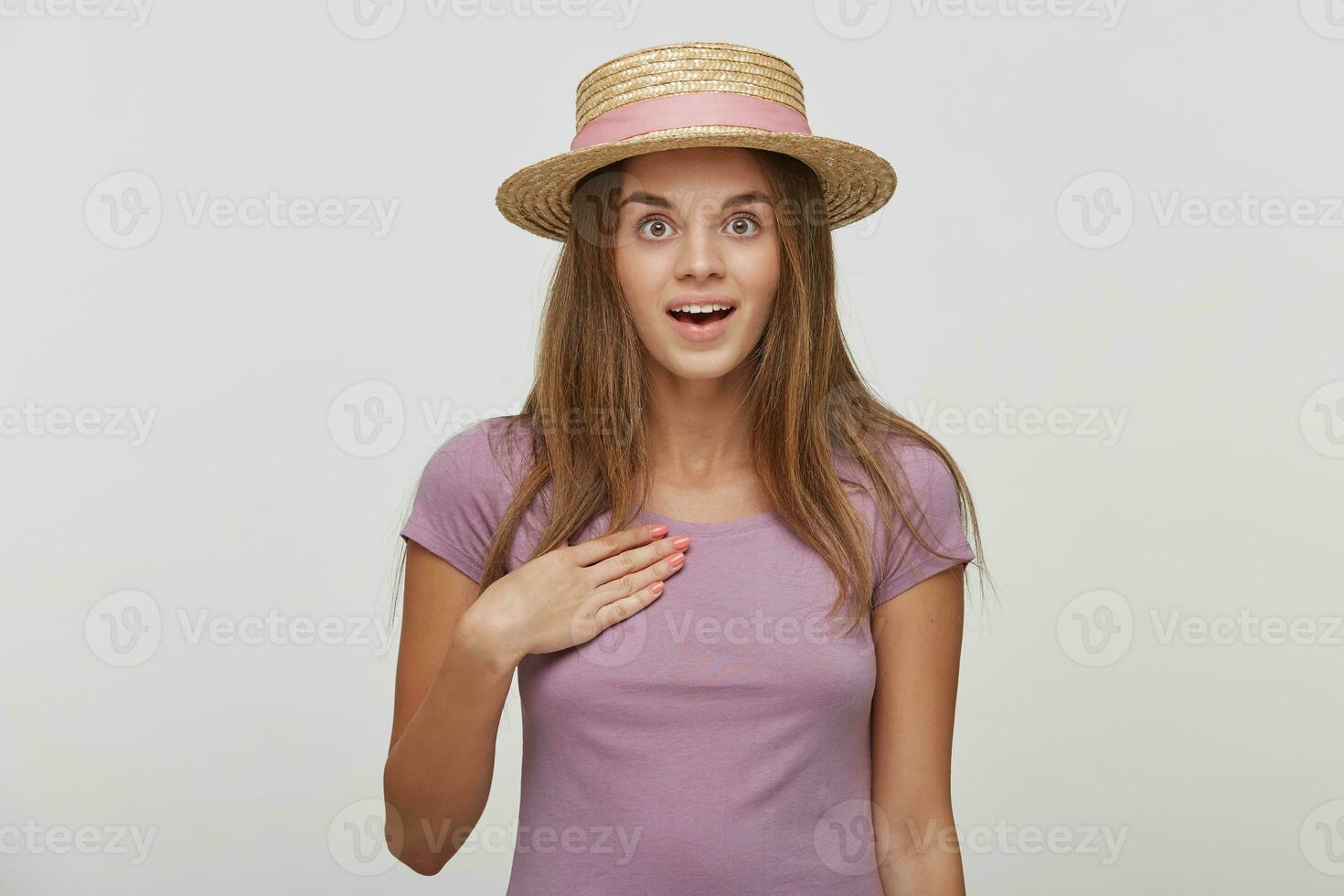 Portrait of beautiful female with surprised expression, looks with bugged eyes and keeps mouth open, indicates at herself, isolated over white background. Human reaction and emotions concept photo