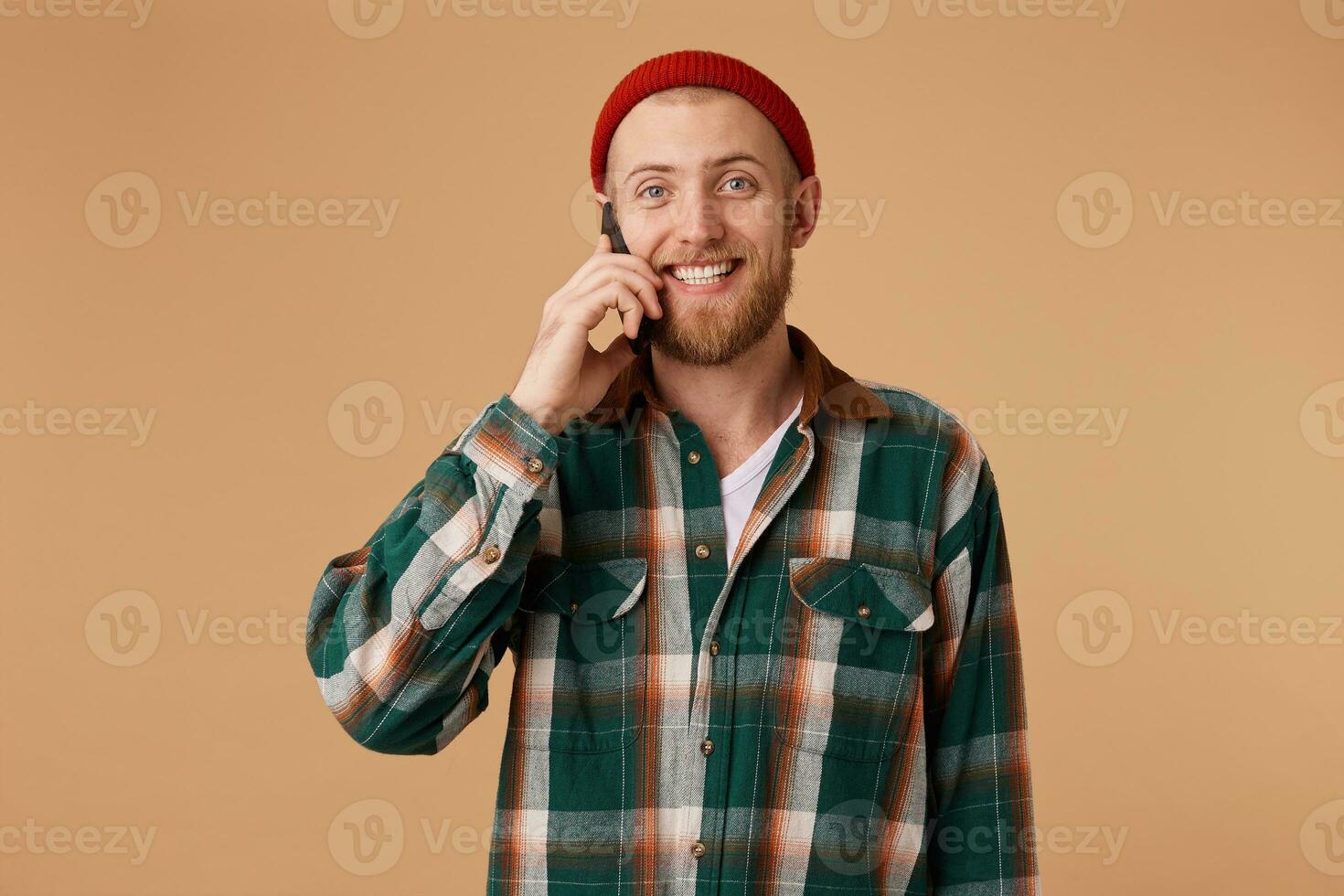 Young guy has pleasant phone conversation happy bearded A man speaks on the phone smiling sincerely receives good news shares good events communicates with his girlfriend. photo