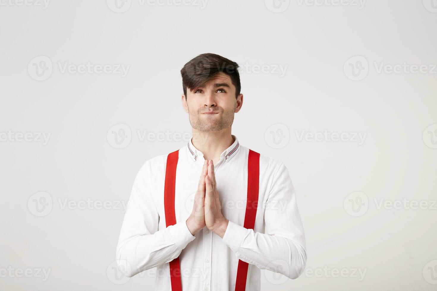 un joven hombre es muy esperanzado para el ayuda de mayor potestades. un chico tiene doblada palmas en frente de él representa un oración mirando hacia arriba con el esperanza, haciendo un desear. foto