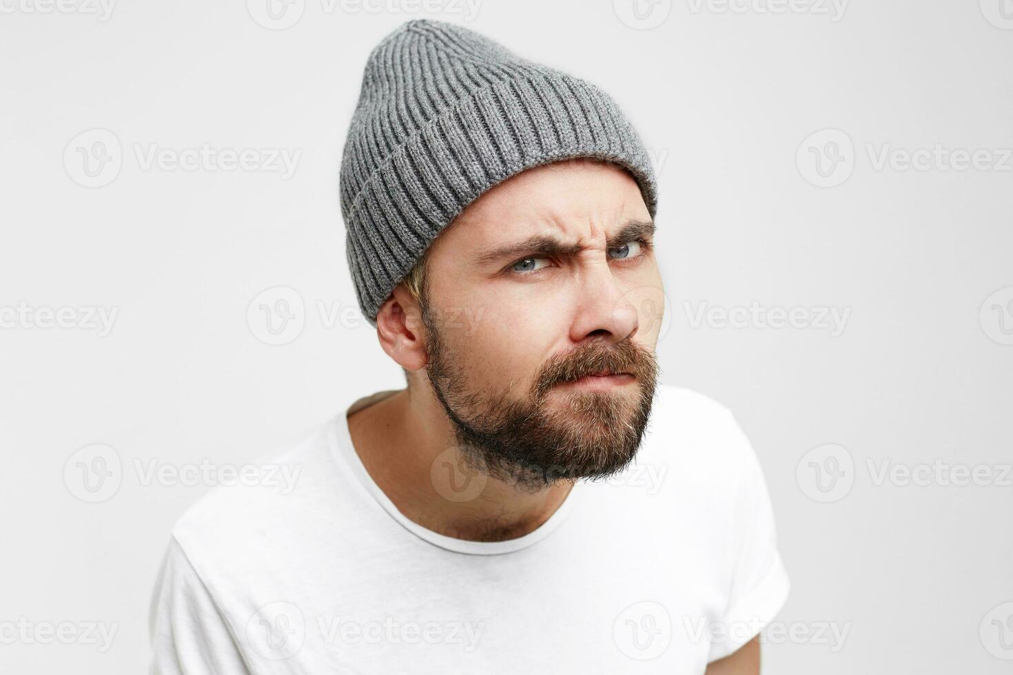 Studio photo of a young man, as if looking into the peephole with interest, eyes narrowed, shrill, meticulously, waiting until open, the neighbor came complaining about the noise, white background