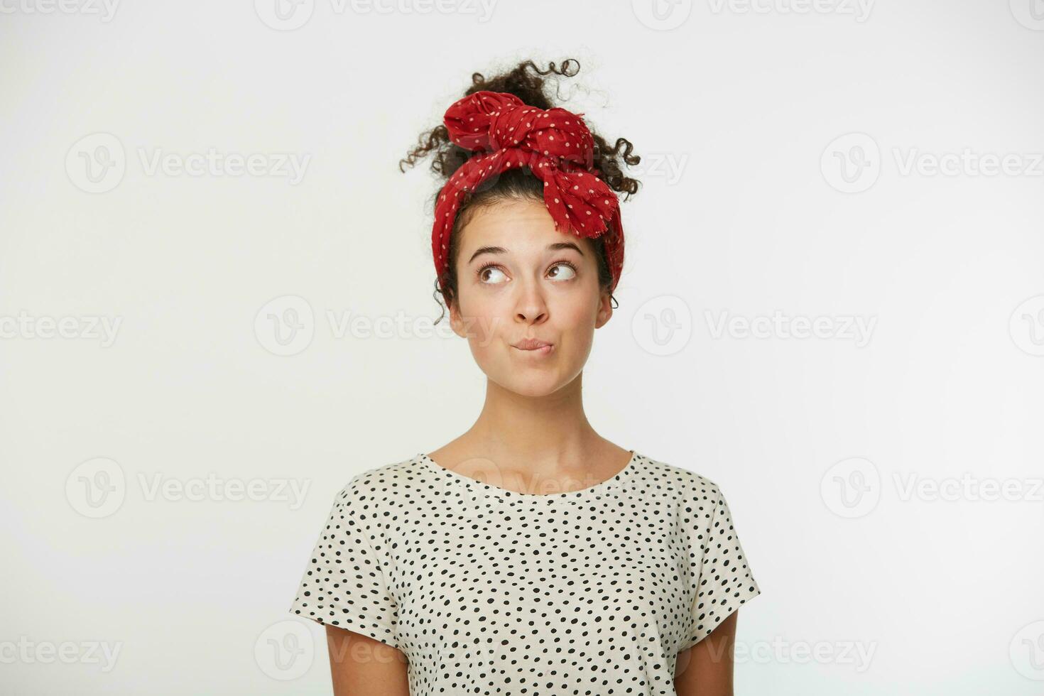 estudio retrato de hermosa joven mujer pensando y mirando hacia arriba. niña poco su inferior labio como Si haciendo arriba plan en mente, mientras mirando aparte, falto a hacer algo. terminado blanco antecedentes foto