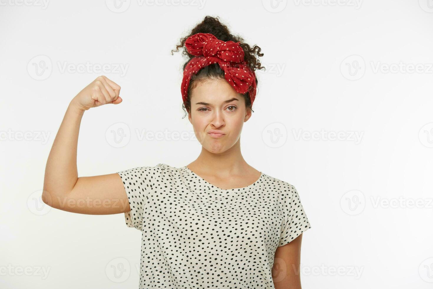 Portrait of beautiful pretty feminist woman proud from girl power and ready to face any challenges. The strong lady fight with confident. Shows strength with raised hand. Over white background photo