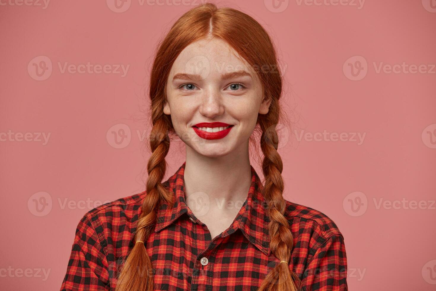 cerca arriba de joven positivo jengibre hembra sonrisas en general y demostración su blanco dientes a el mundo. foto