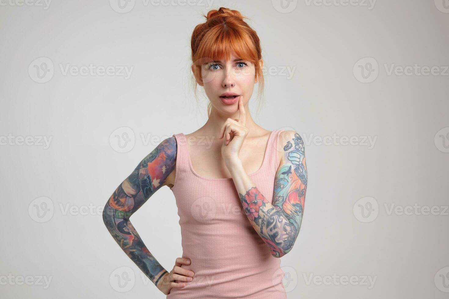 Indoor portrait of young ginger female posing over white wall photo