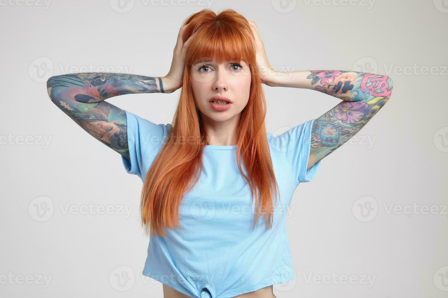 Indoor portrait of young ginger female posing over white wall photo