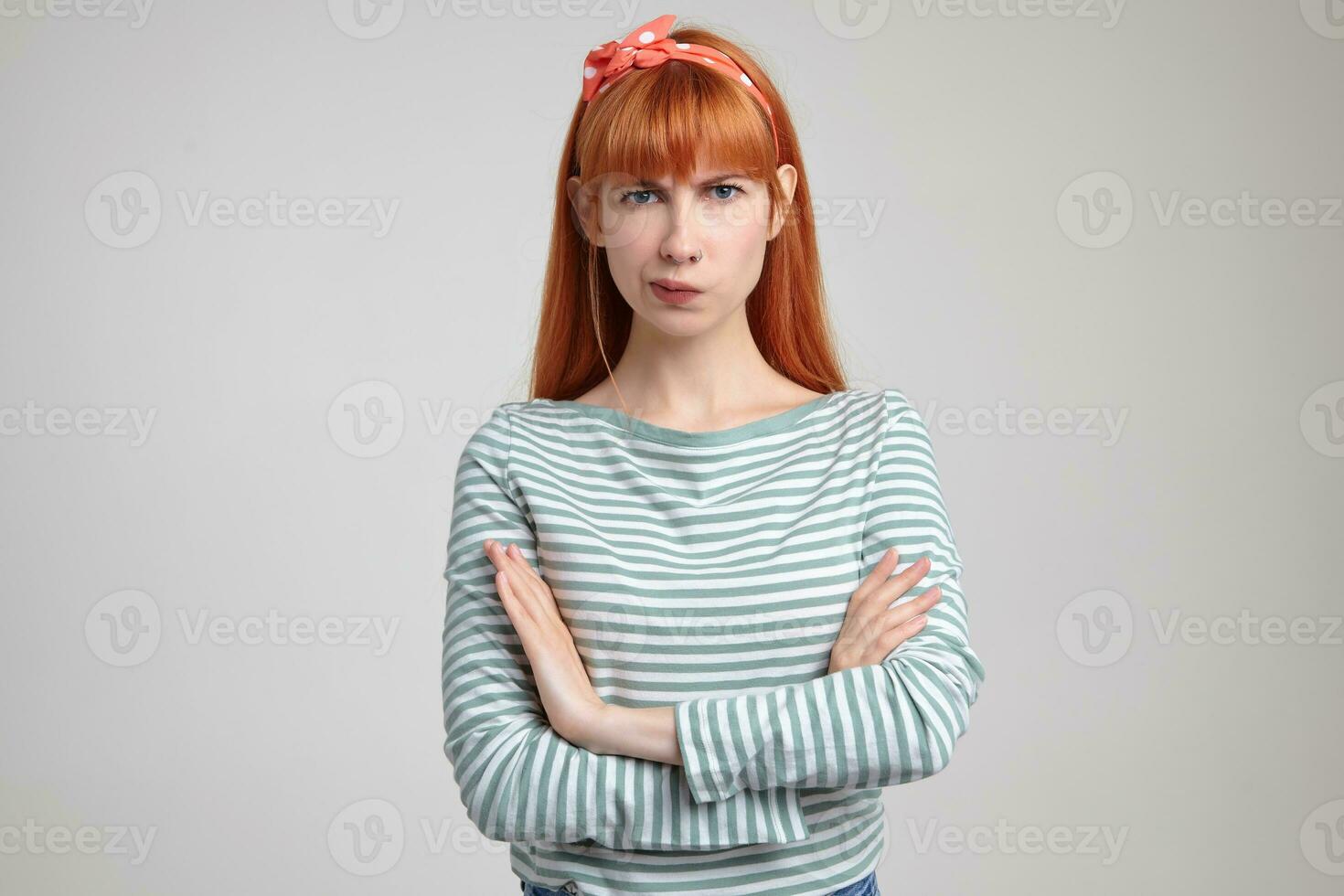 Indoor portrait of young ginger female posing over white wall curving her lips with irritated facial expression photo