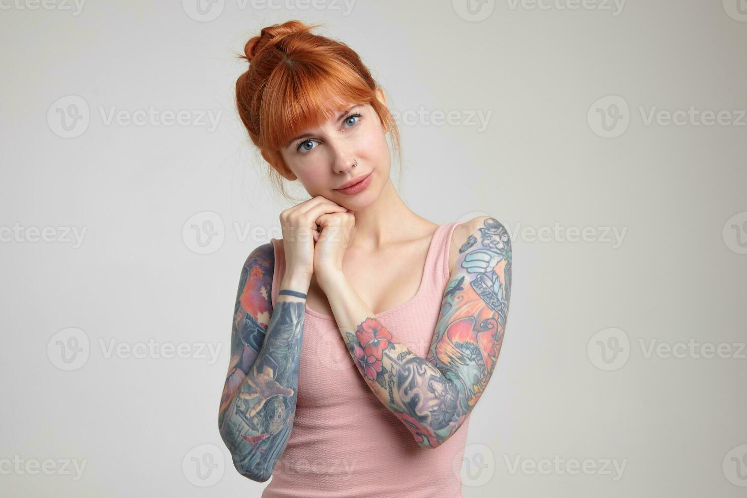 Indoor portrait of young ginger female posing over white wall photo