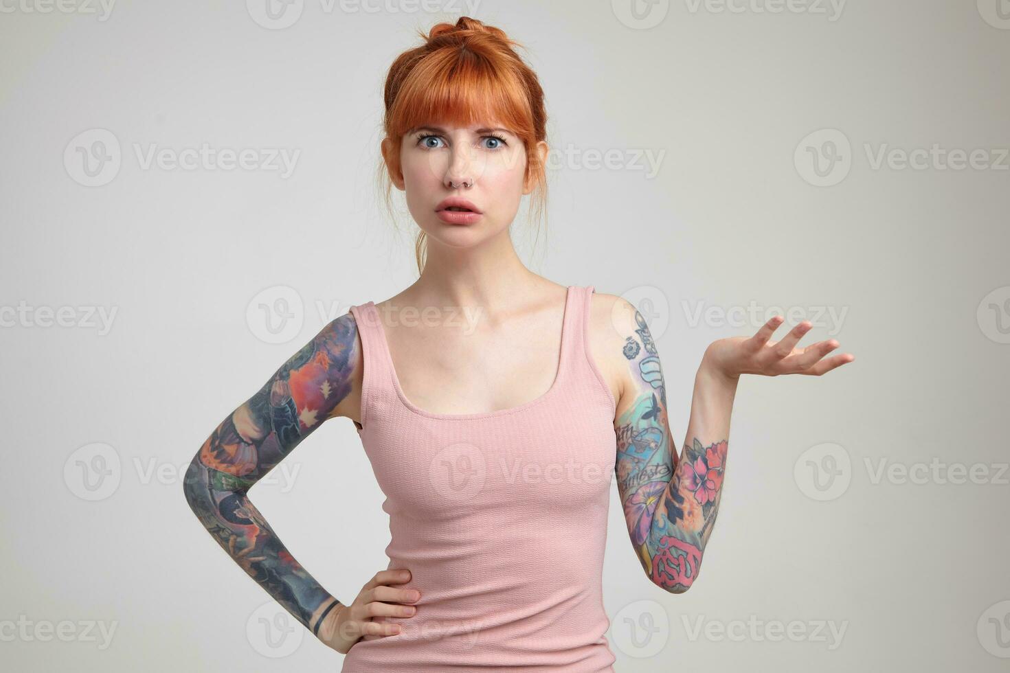 Indoor portrait of young ginger female posing over white wall photo