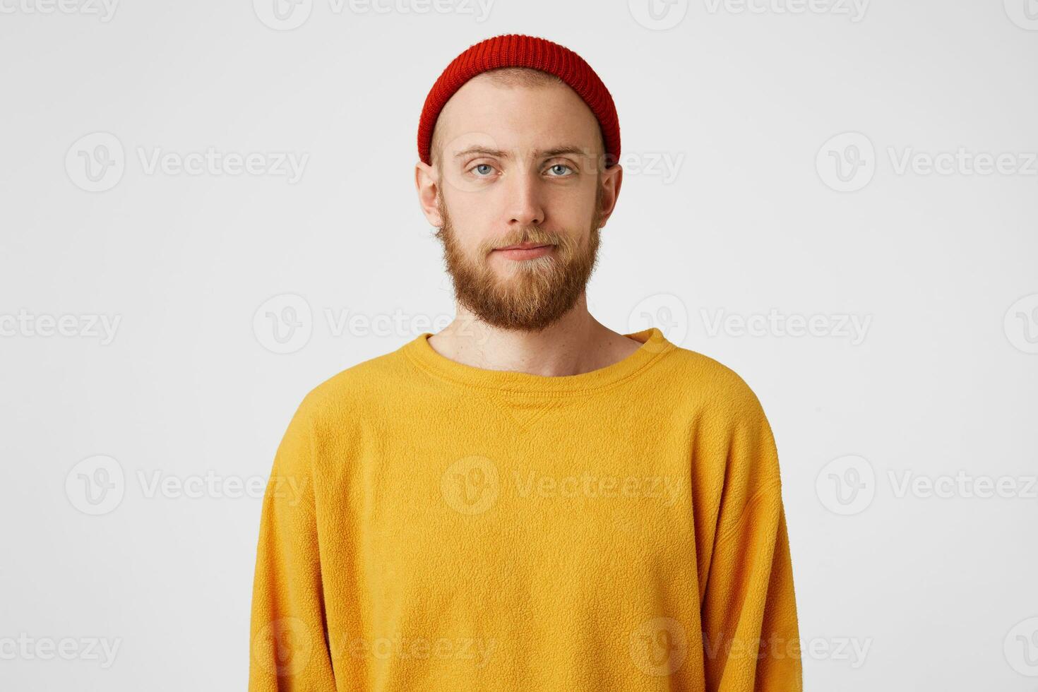 A young handsome guy with a beard,blue eyes, is standing with an indifferent, dissatisfied,apathetic face, not interested,adhering to the conditions, agrees to the conditions, is waiting for his turn photo