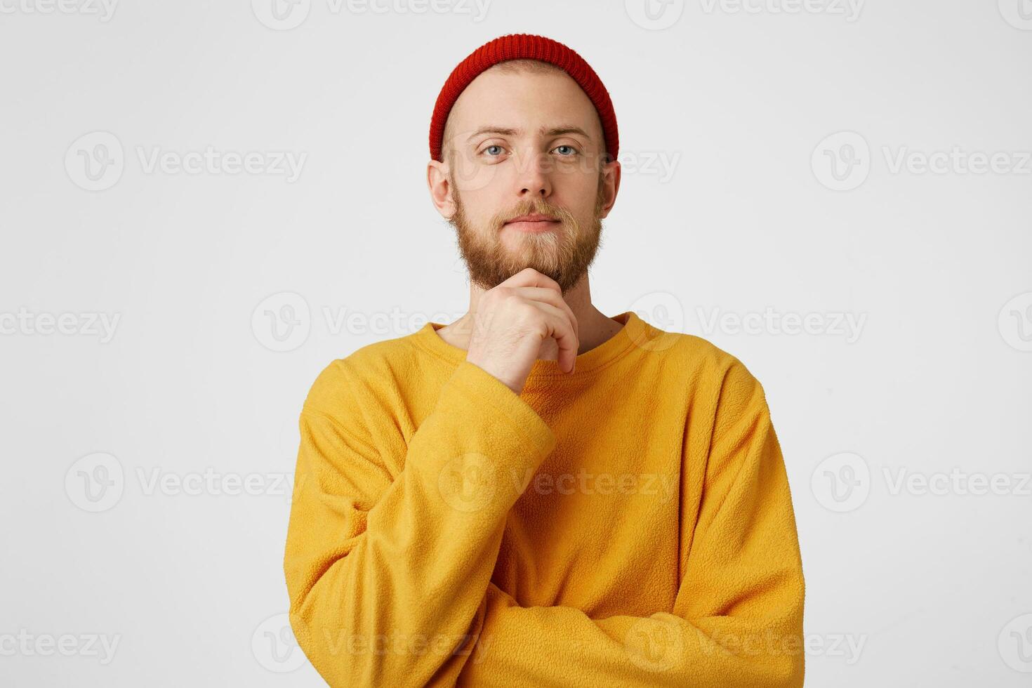 Photo of thoughtful man isolated over white background wall. Thinking arrogant confident young bearded male holding fist on chin