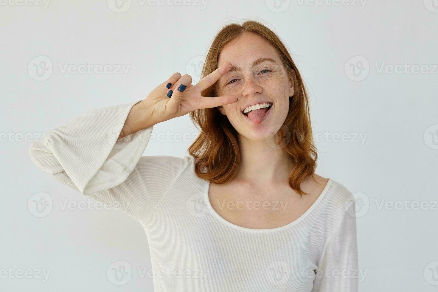 young positive female shows v sign into camera photo