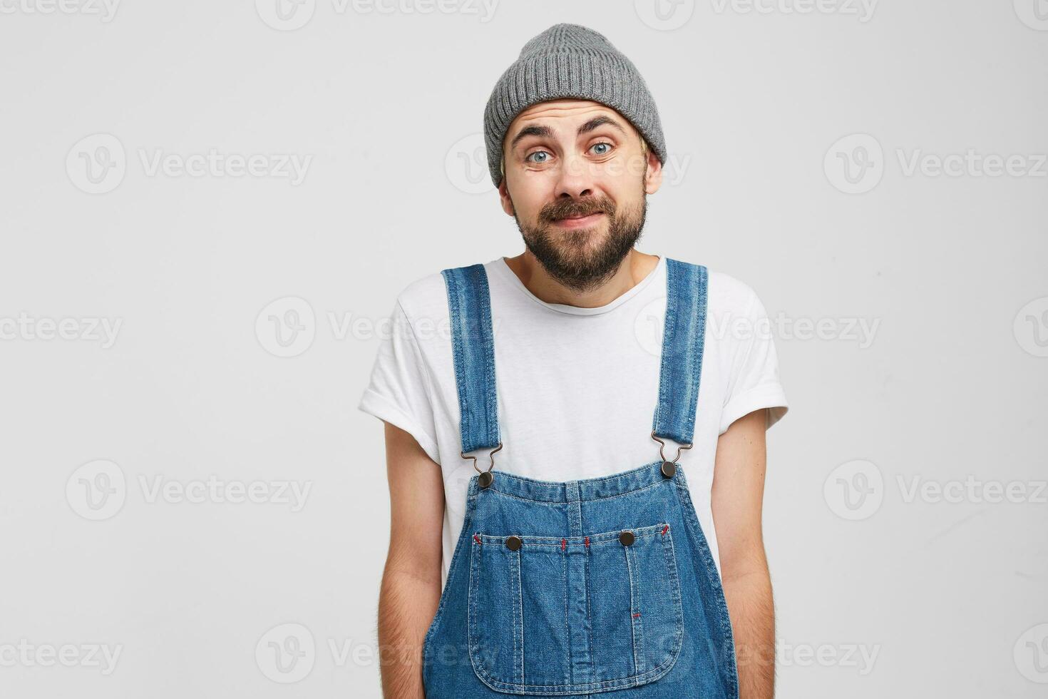 A man stands with a guilty apologetic expression, pretends that he regrets that it happened. Admits that he is guilty but does not know what to do now, looking at the camera, over white background photo