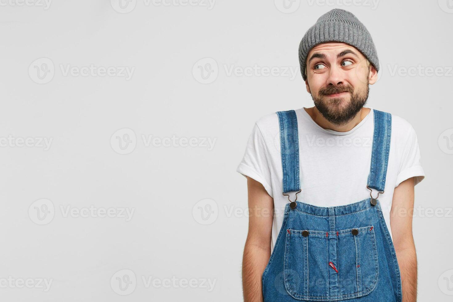 Close up of a young man looks aside on a blank copy space, stands with a guilty apologetic expression, regrets for what happened. Admits his fault. Doubts the correctness of his decision photo
