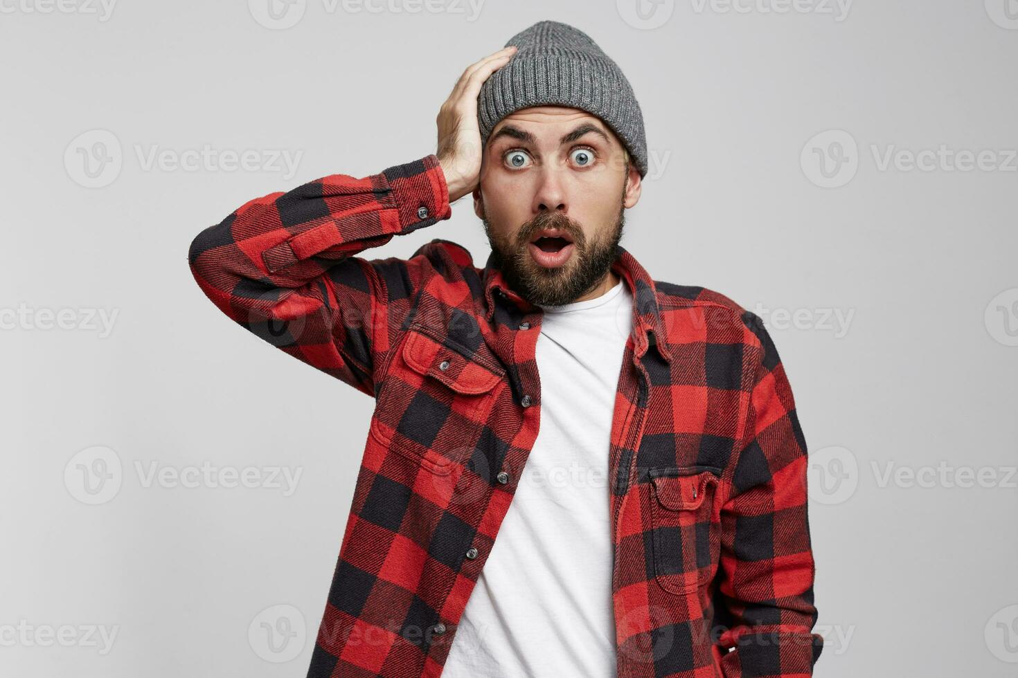 asustado hombre agarrado su cabeza. sorprendido masculino, mantiene boca abierto, siendo aturdido, terminado blanco antecedentes. horizontal Disparo de conmocionado joven masculino, expresa genial sorprendido, catástrofe tenido sucedió foto