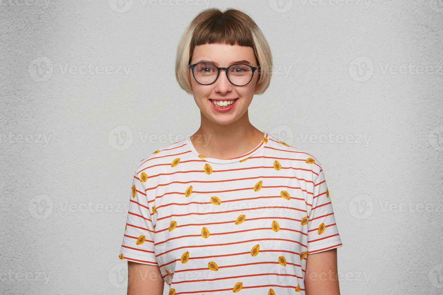 Portrait of happy beautiful young woman wears striped t shirt and glasses smiling and looks directly in camera isolated over white background photo