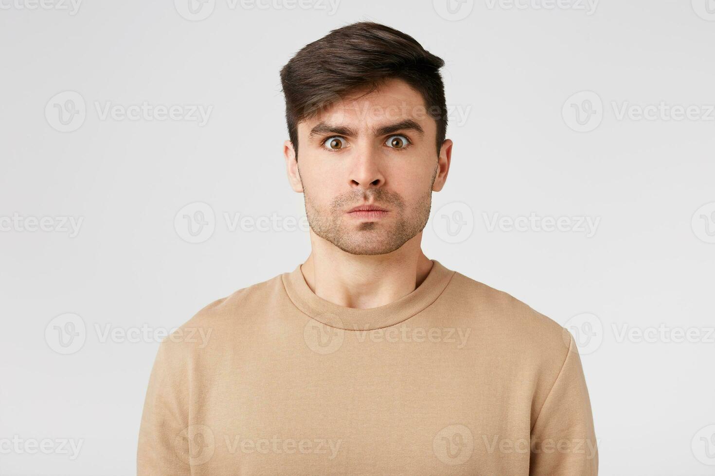 Tense serious guy dressed in nude long-sleeve experiencing angr,but restrains it.Man barely restrains himself, in order not to start the quarrel,ready to explode and tell many comments,his displeasure photo