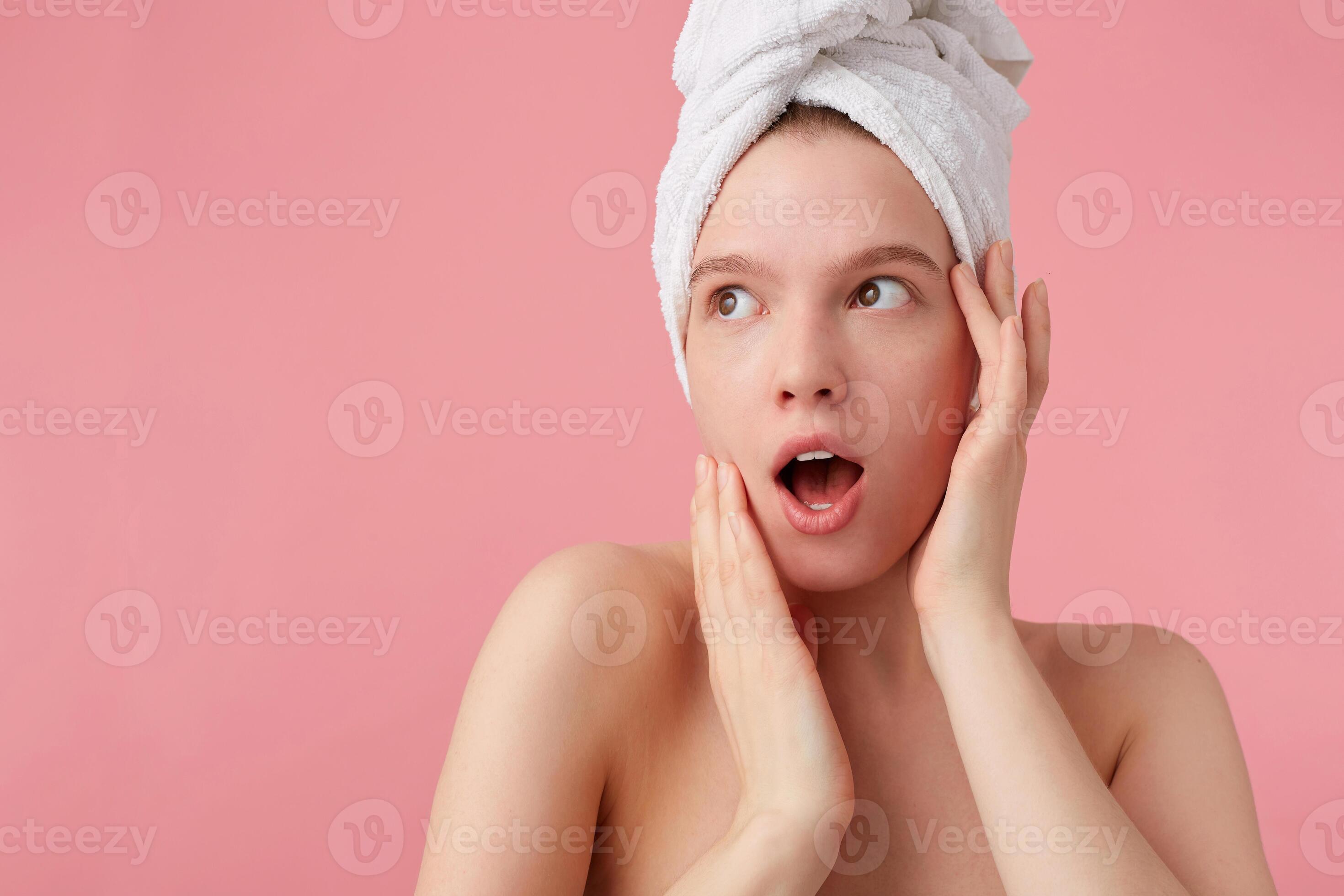 Close up of shocked young woman after shower with a towel on her head