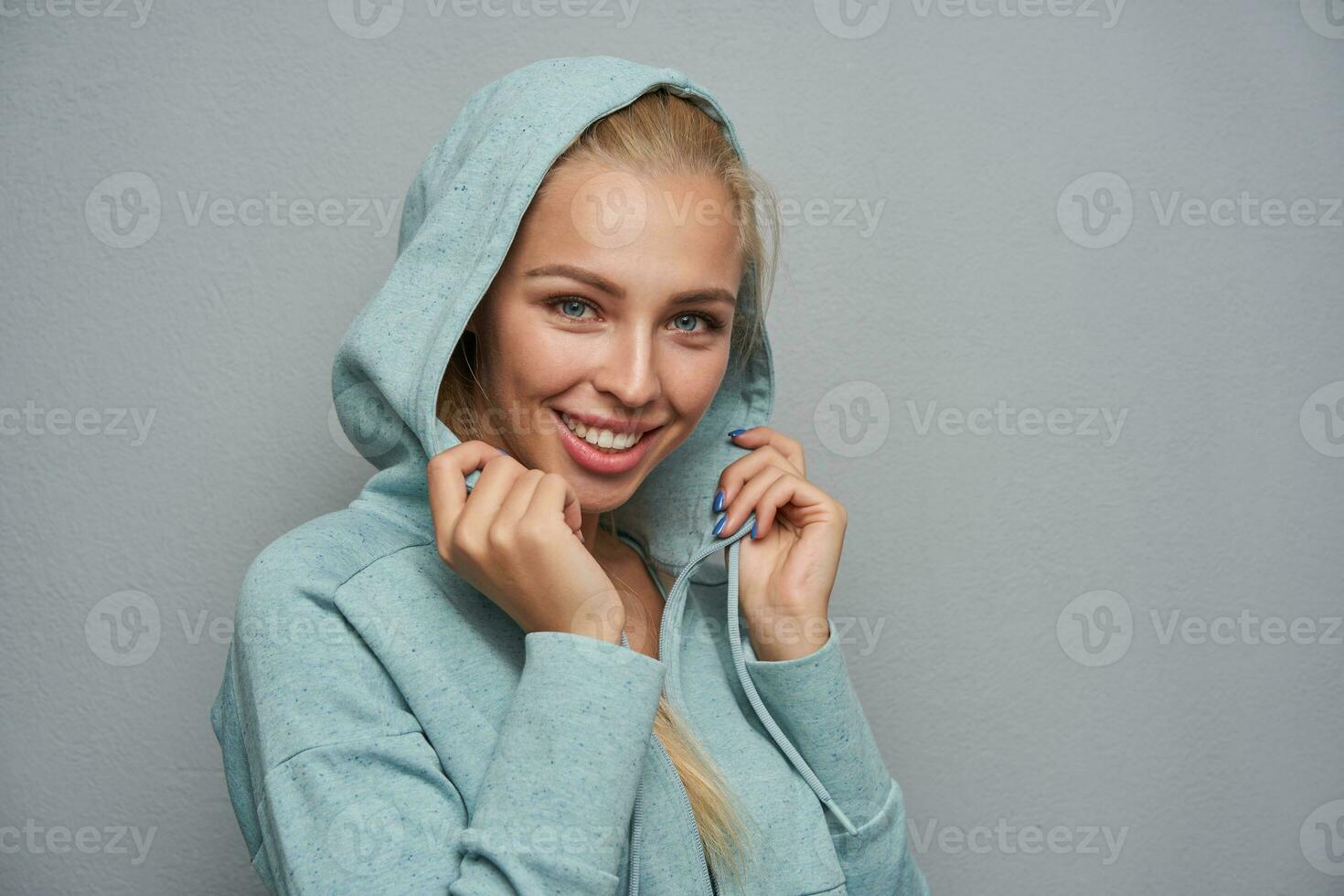Portrait of beautiful positive young blonde lady with charming smile photo