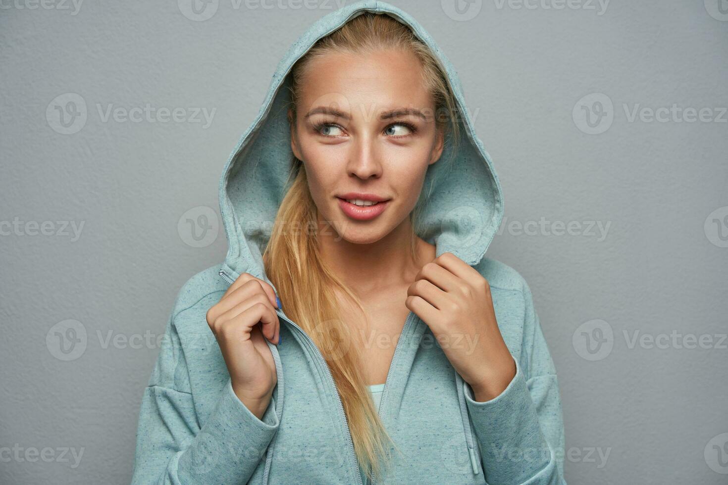 de cerca de atractivo de ojos azules joven rubia mujer en deportivo menta Saco mirando afirmativamente aparte foto