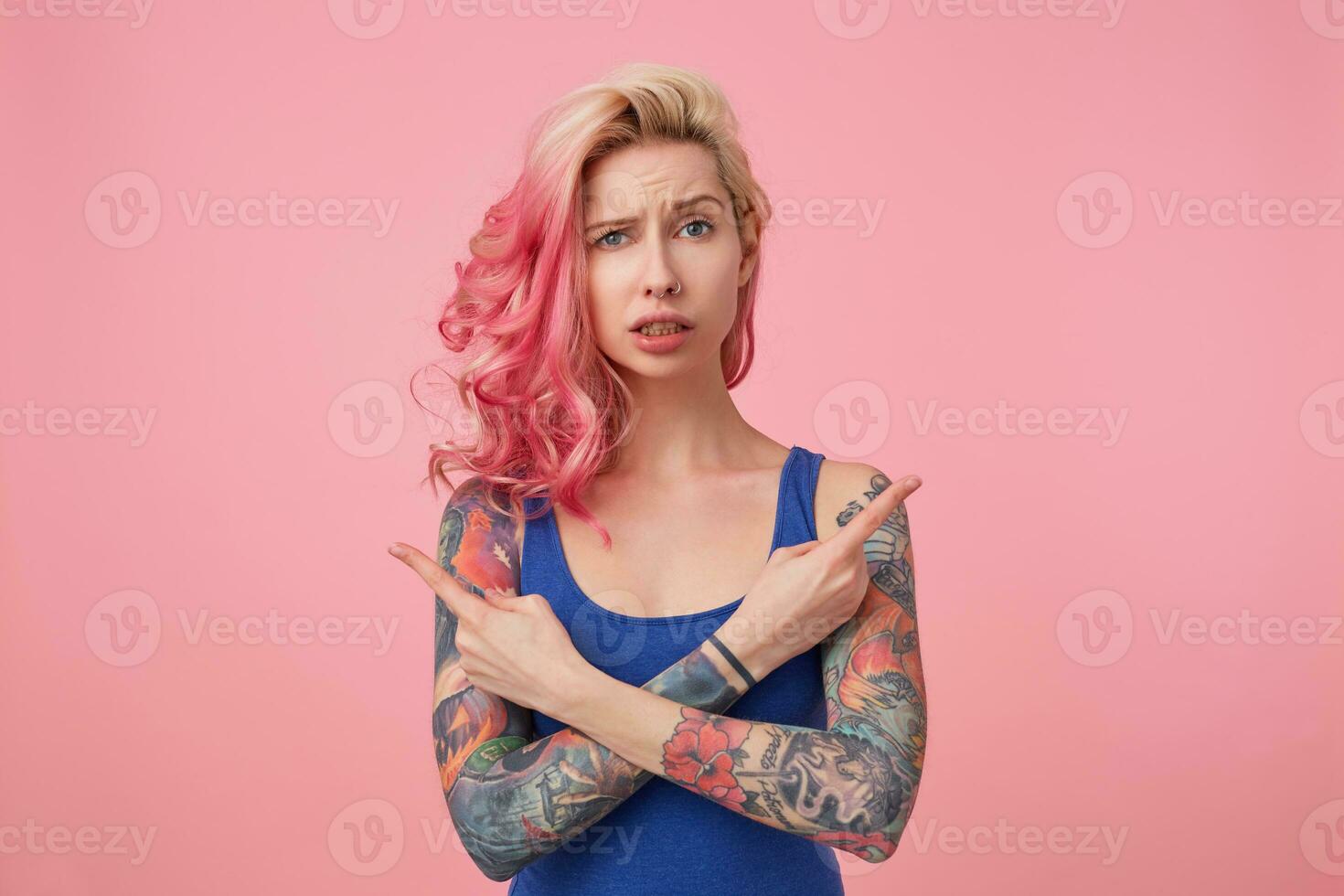 Young beautiful disconnected pink haired lady in blue t-shirt, confused ...