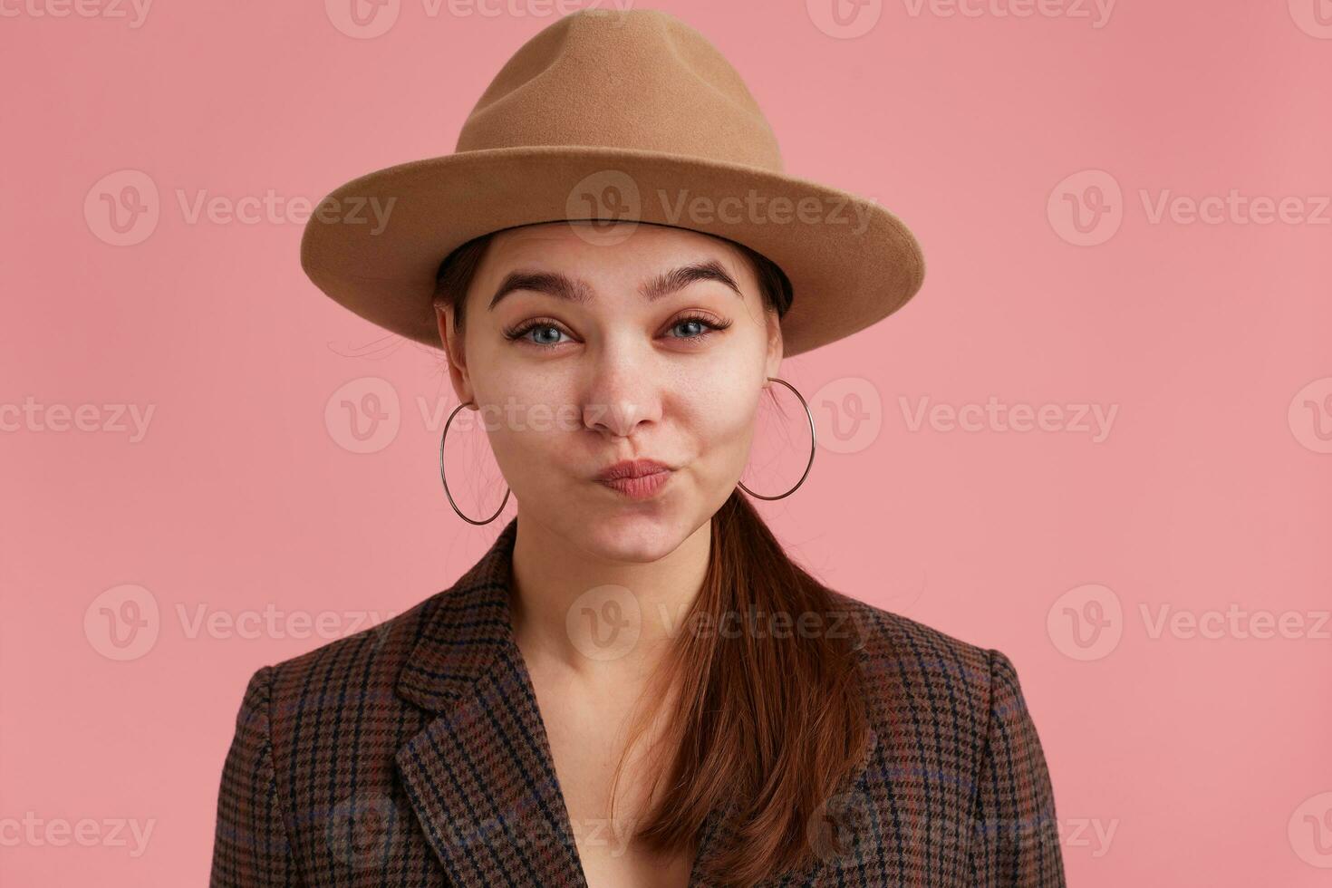 cerca arriba de disgustado joven dama ingenio arco labios, Cejas con indignación aumentó. mirando a cámara aislado terminado rosado antecedentes. foto