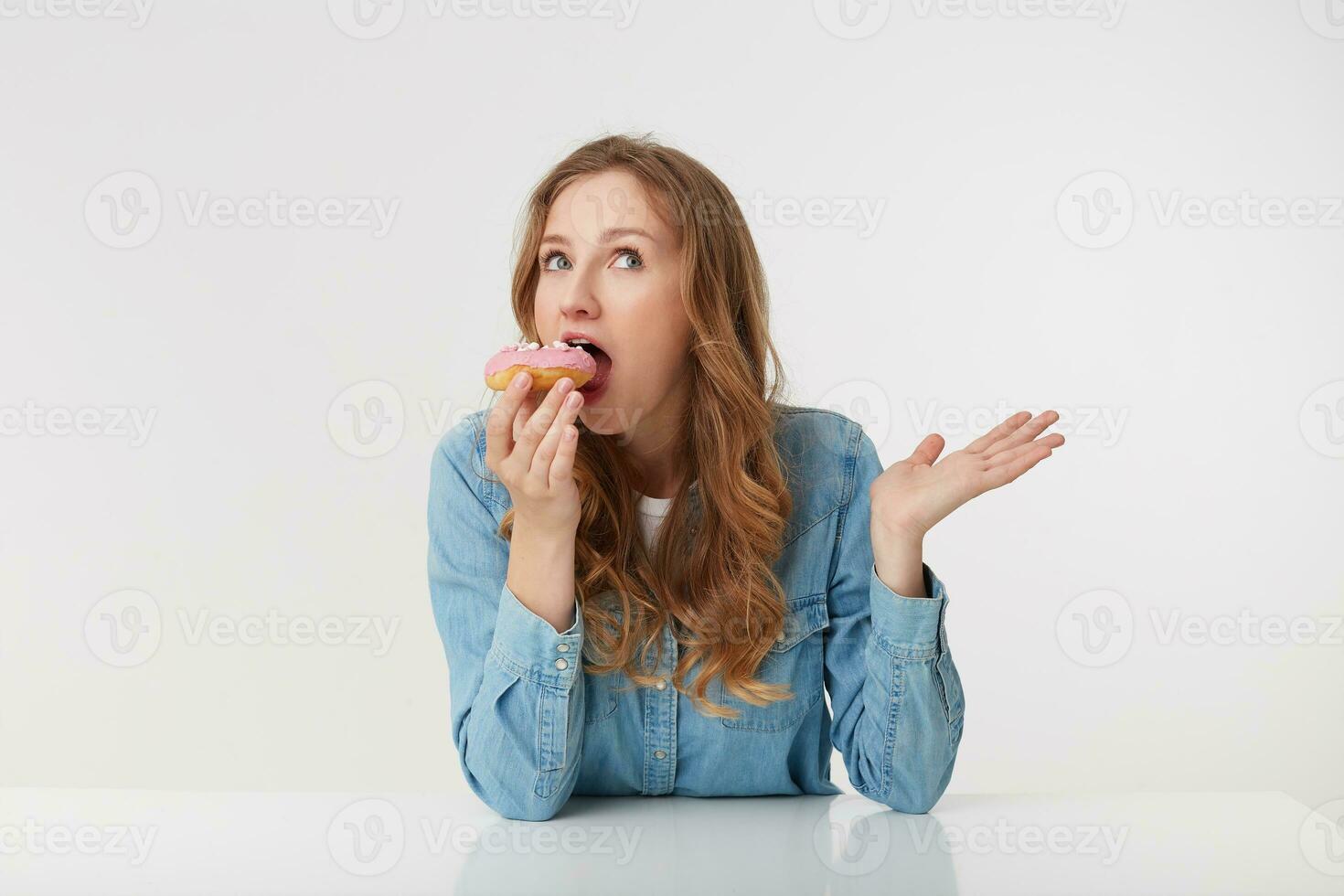 Photo of young pretty woman which is going to bite off a delicious kidney, isolated over white background.