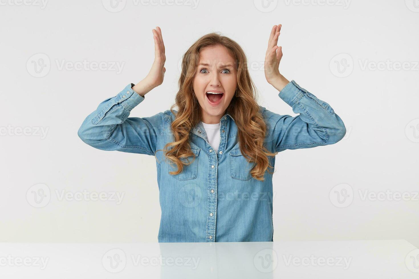 Photo of cute young blonde woman raises his hands up and scream in shock, isolated over white background. People and emotion concept.
