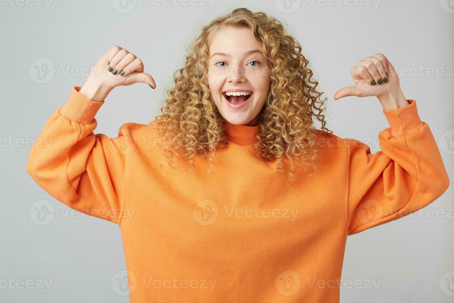 retrato de alegre rubia mujer en básico ropa sonriente y apretando puños me gusta ganador con pulgares señalando en su, aislado terminado blanco antecedentes foto