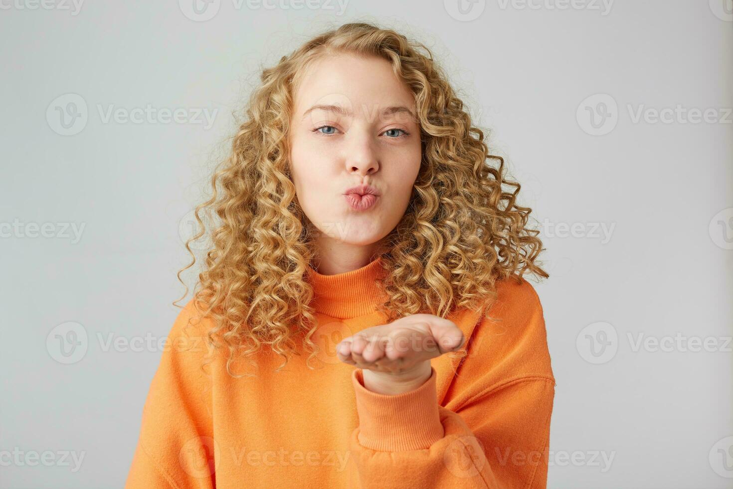 Portrait of lovely sweet girl with modern hairdo blowing air kiss with pout lips one palm at camera isolated on white background, demonstrate feelings to her boyfriend photo