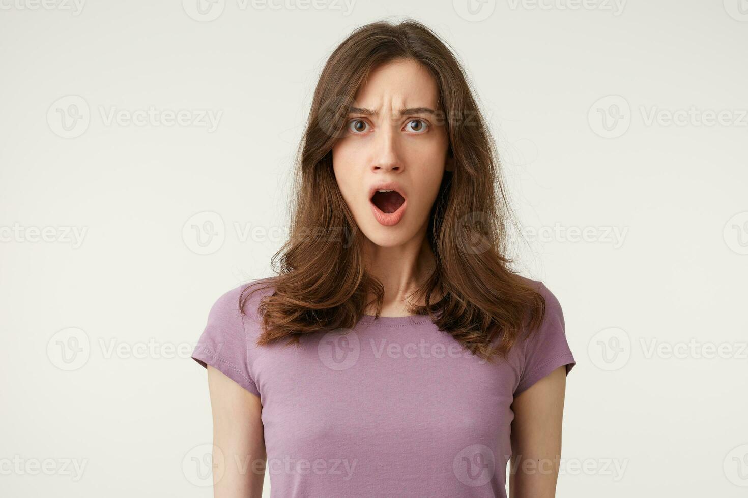 Excuse me Portrait of offended indignant young female with opened mouth, feeling outraged, standing at blank studio wall with copy space for your content photo