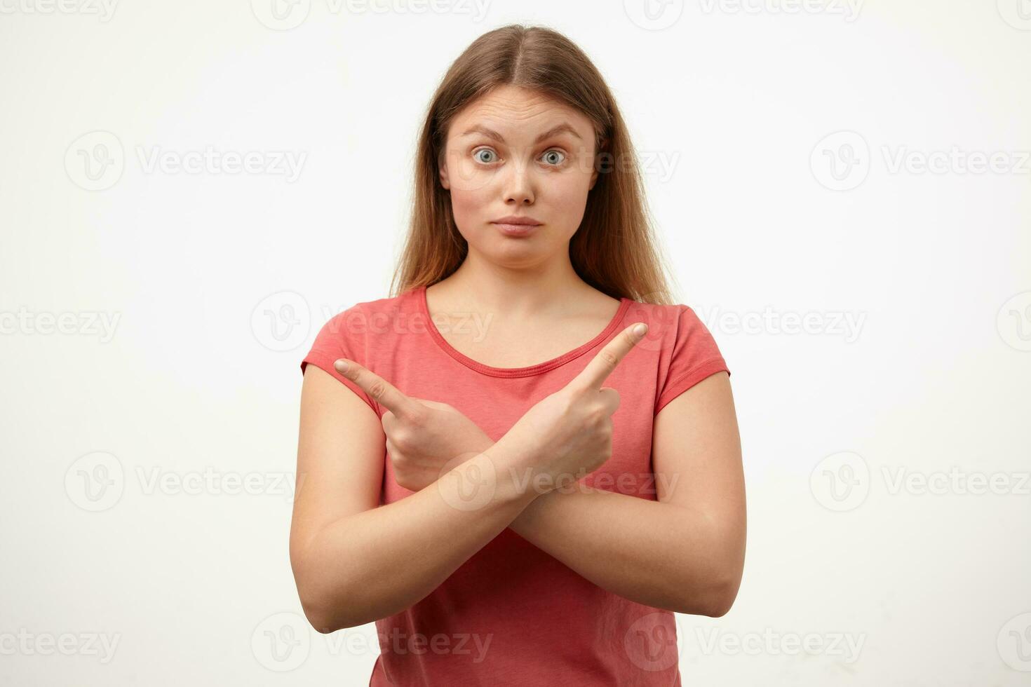 Amazed young blonde lady with casual hairstyle crossing hands on chest while showing in different sides and raising surprisedly eyebrows, isolated over white background photo