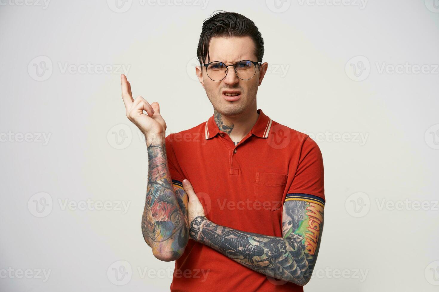 Guy with glasses looks annoyed, displeased,dismissive. The master is not satisfied with the result, the creative nature, something wrong.Hold one hand up and gesticulate, one hand pressed under armpit photo