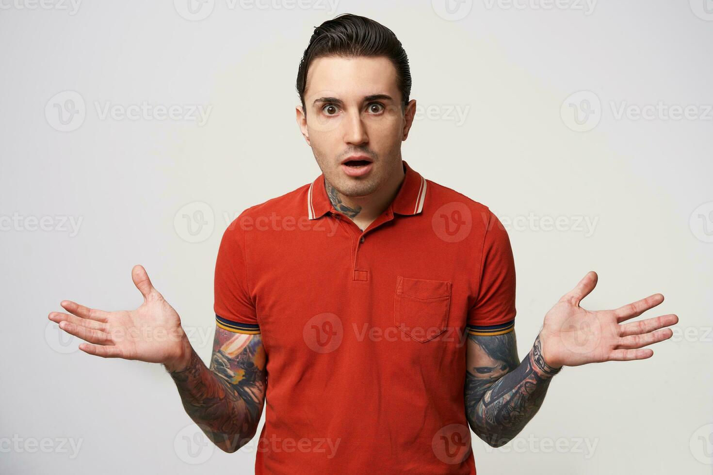 How could it happen What to do Uncomprehending bewildered puzzled perplexed confused man pointing to the sides with hands. Portrait of a young guy on white background photo