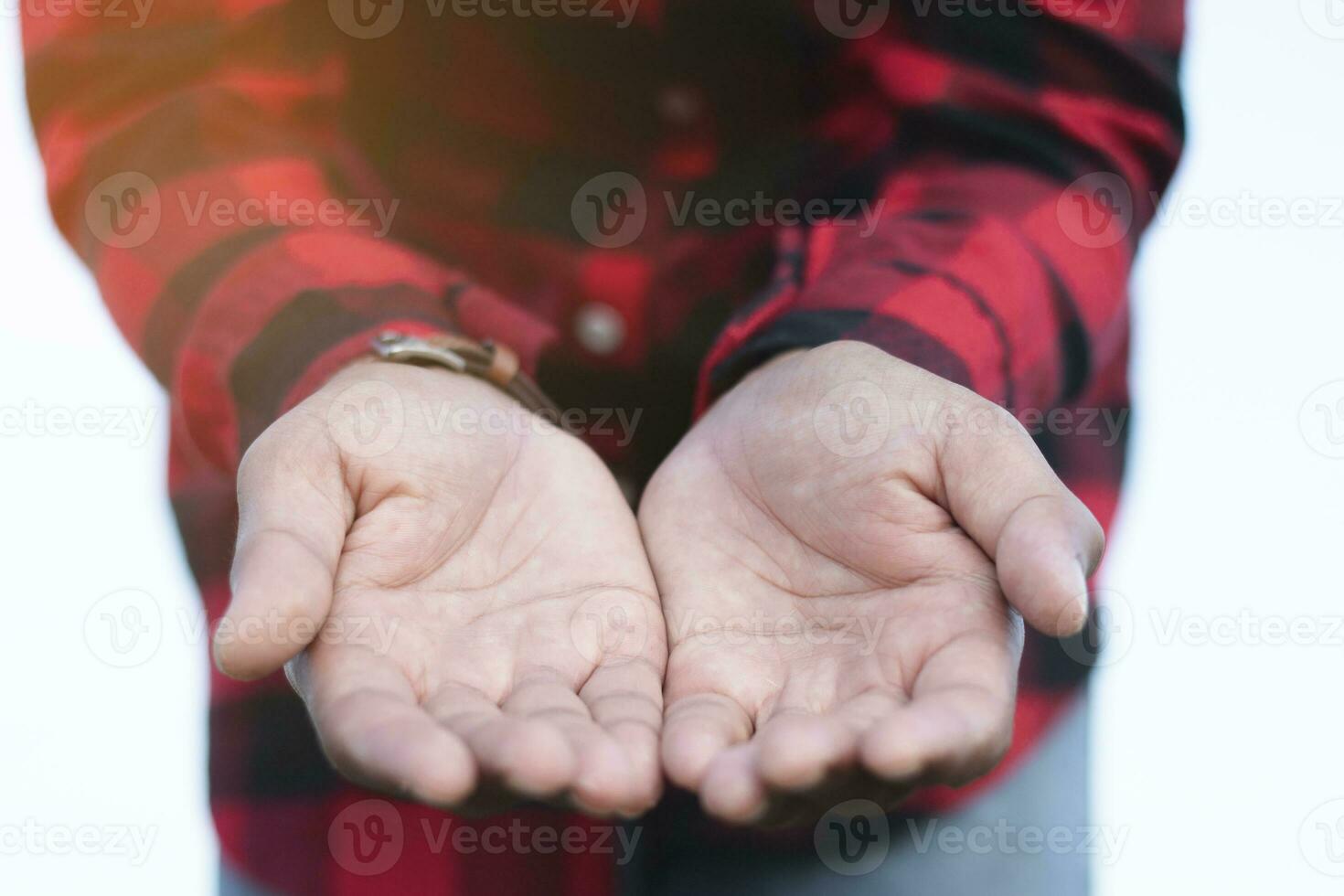 A man in a checkered shirt is holding out a hand, liberation concept, sharing, kind spirit. photo