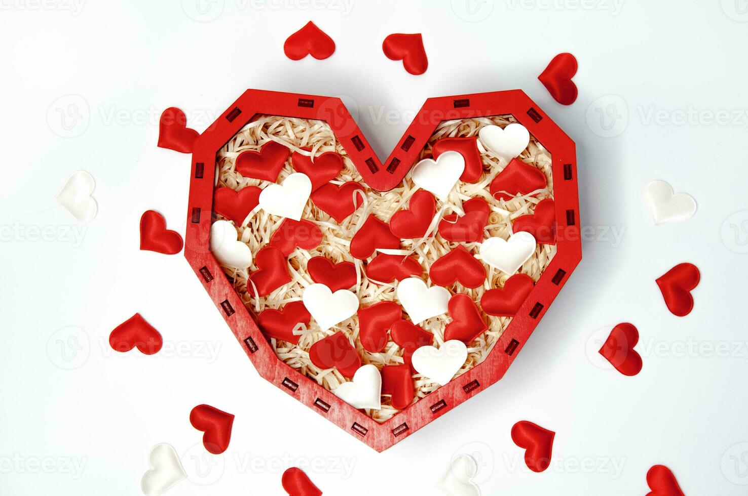 Red heart with white and red confetti in the form of hearts on a white background photo