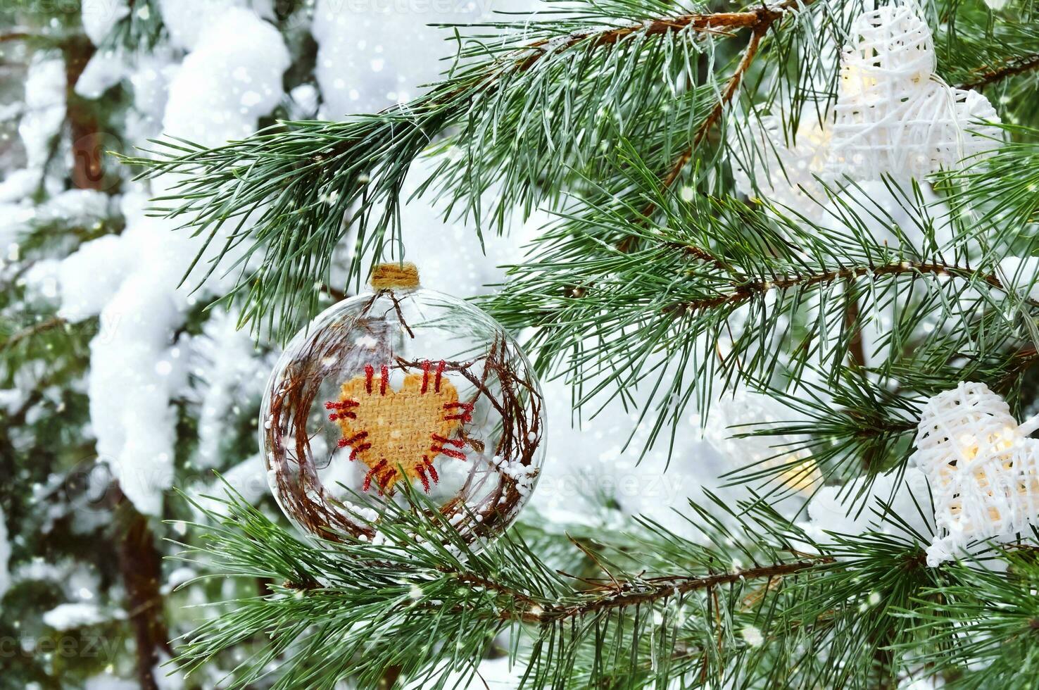 Christmas and New Year holidays background. Christmas decoration close-up on the branches of a snowy spruce in the forest photo