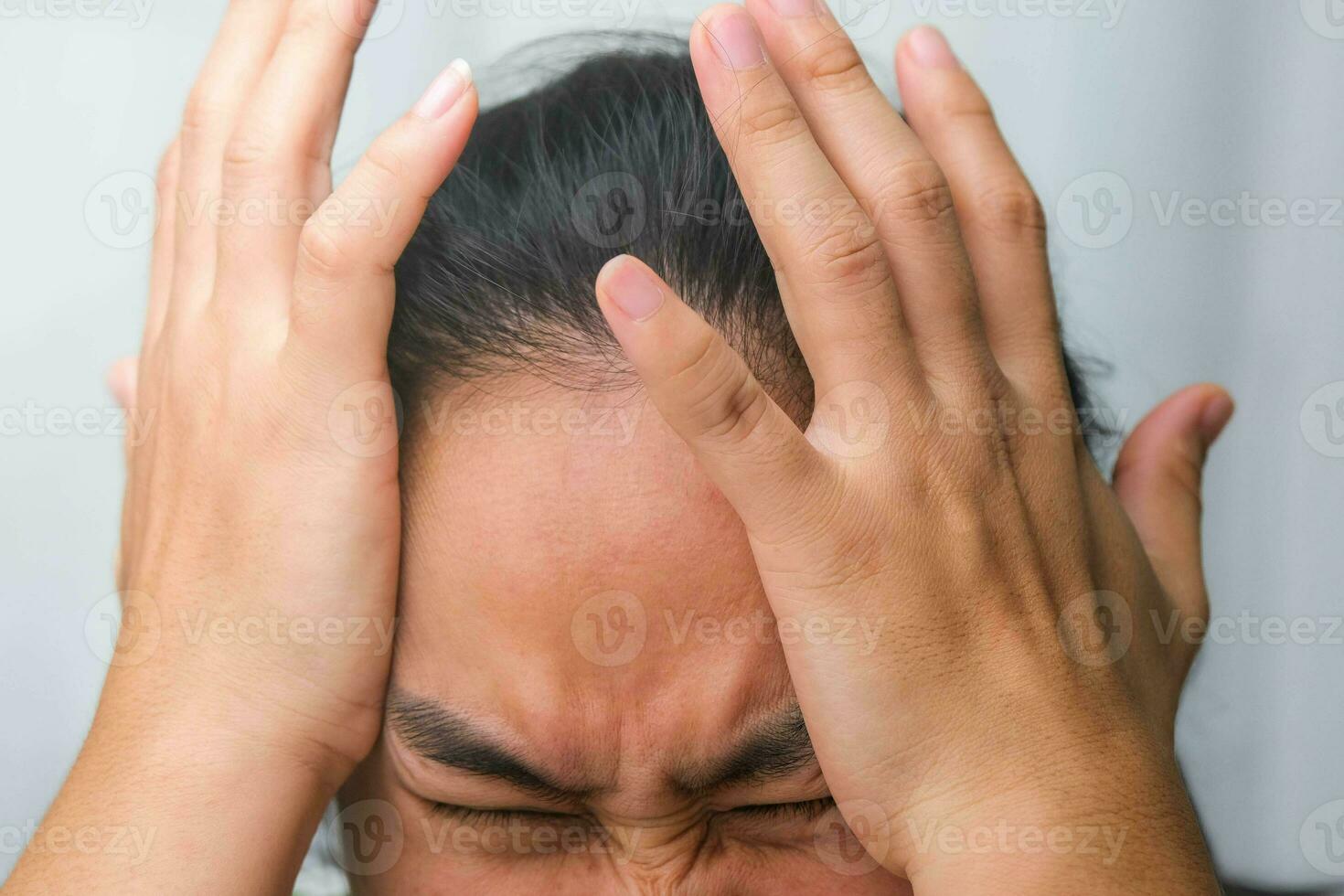 Young woman having headache against white curtain background in room. An adult woman touching head because of headache or migraine. Hands on head. photo