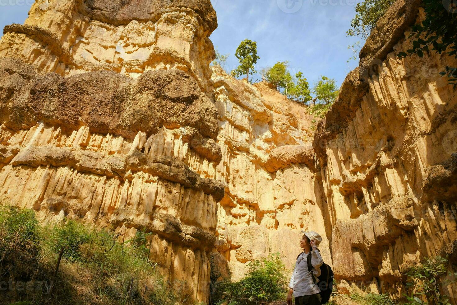 Female geologist with backpack exploring nature trail in forest and analyzing rock or gravel. Researchers collect samples of biological materials. Environmental and ecology research. photo