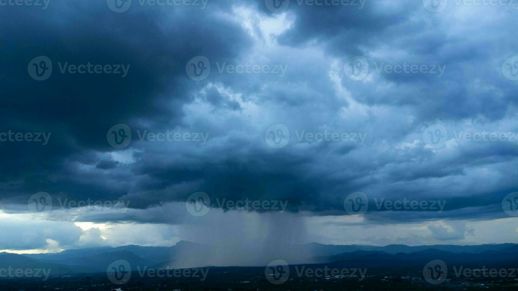 aéreo panorámico ver de comunidad y tierras de cultivo con enorme tormenta nubes en el antecedentes. aéreo ver de el lluvia terminado un rural comunidad. lluvia nubes Disparo desde un zumbido. foto